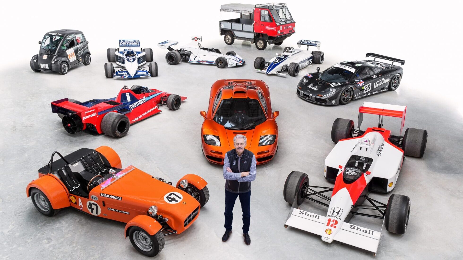 Gordon Murray rodeado de varios coches de carreras y deportivos