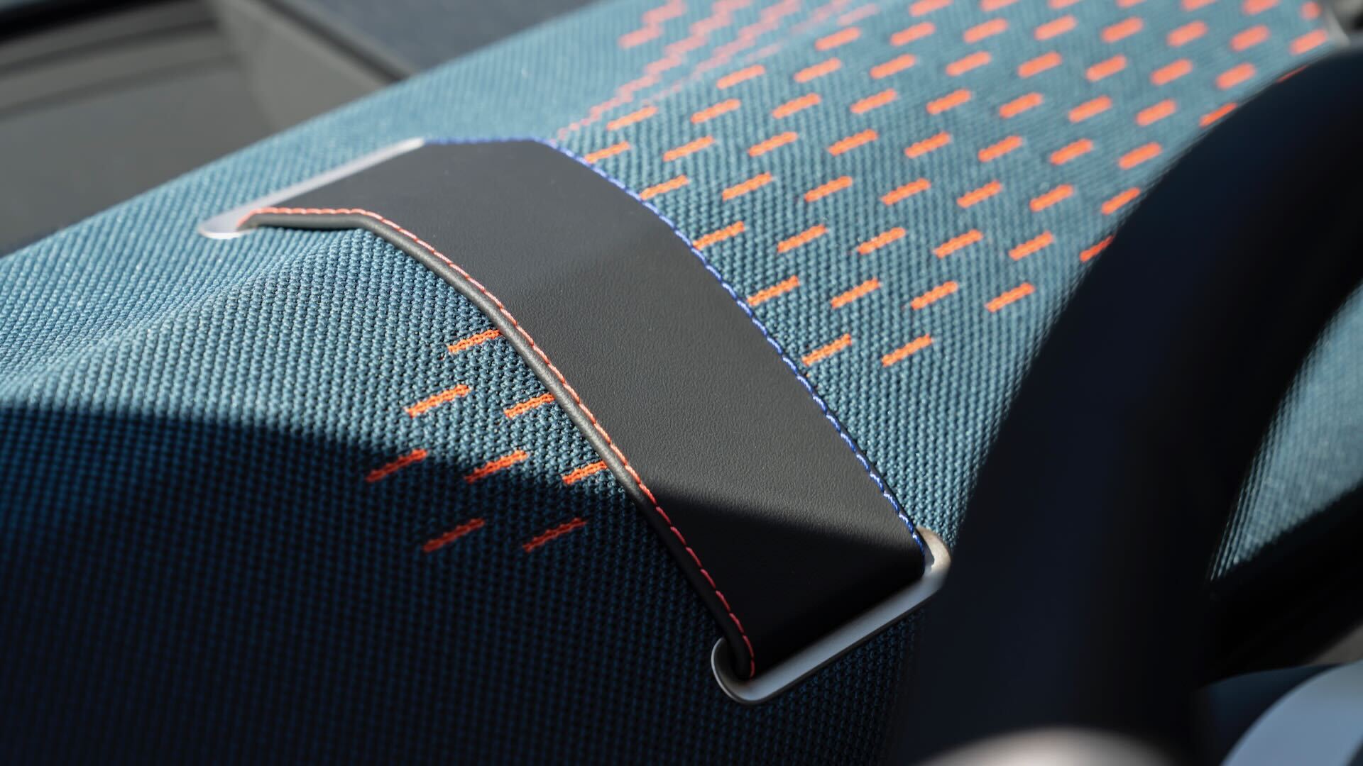 Detalle del interior de un vehículo MINI con tejido reciclado y costuras coloridas.