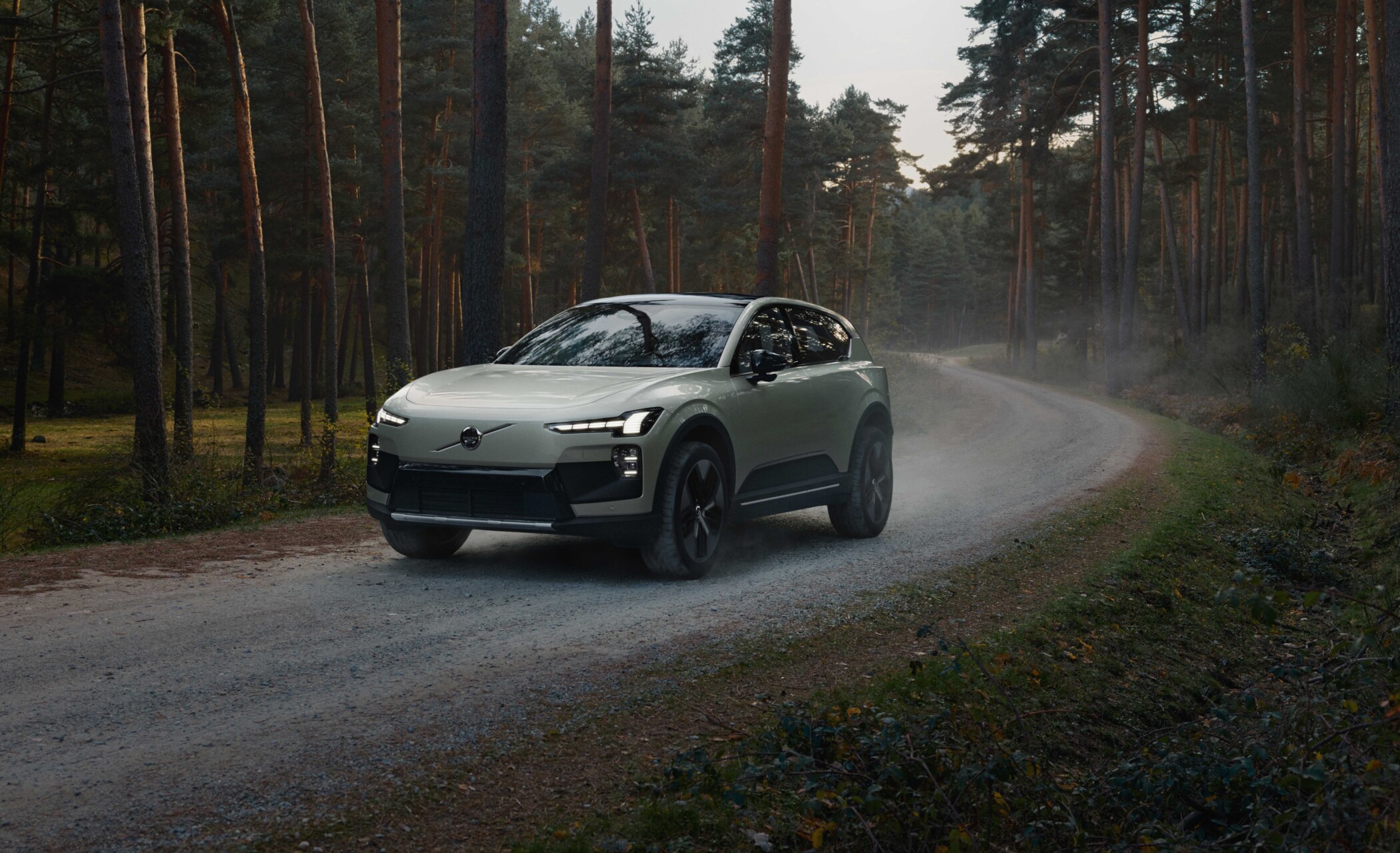 Volvo EX60 circulando por un camino en un bosque