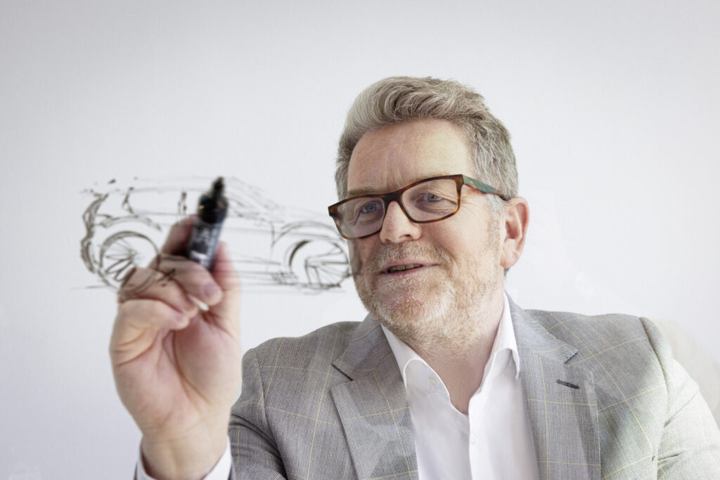 Andreas Mindt dibujando un diseño automotriz en una pizarra