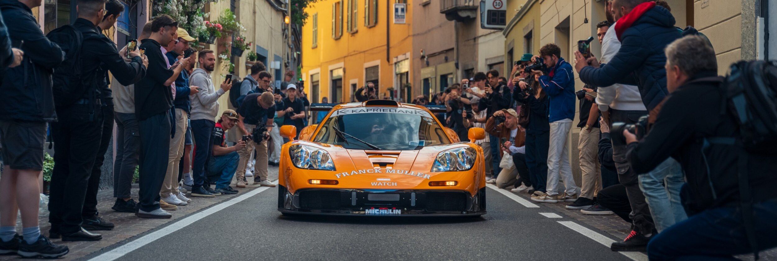 Coche McLaren F1 en una carrera rodeado de fotógrafos