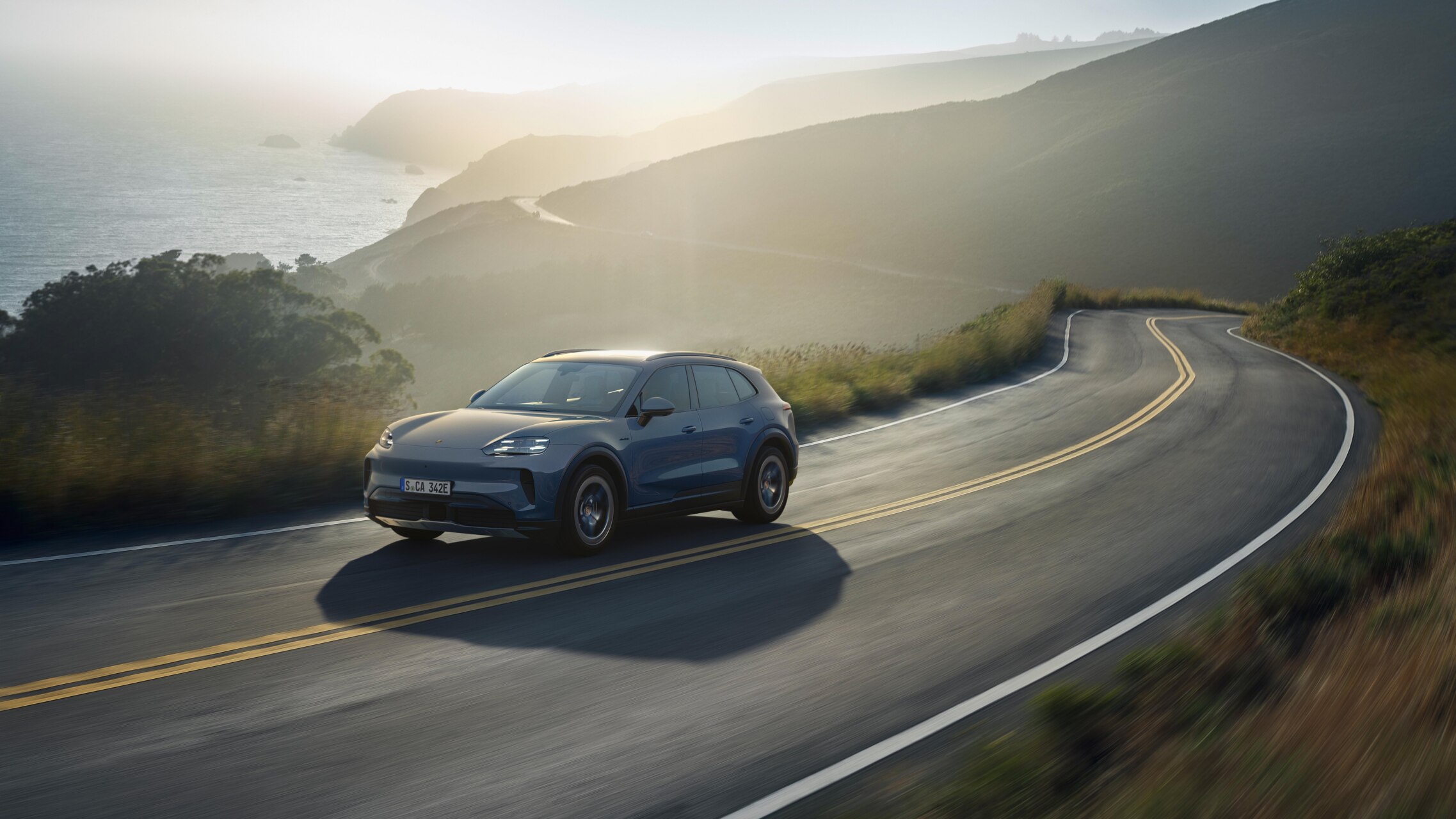 Porsche Cayenne S Electric en una carretera rodeada de naturaleza