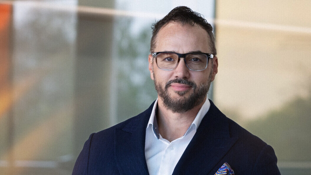 Kemal Curic posando en un entorno moderno y profesional