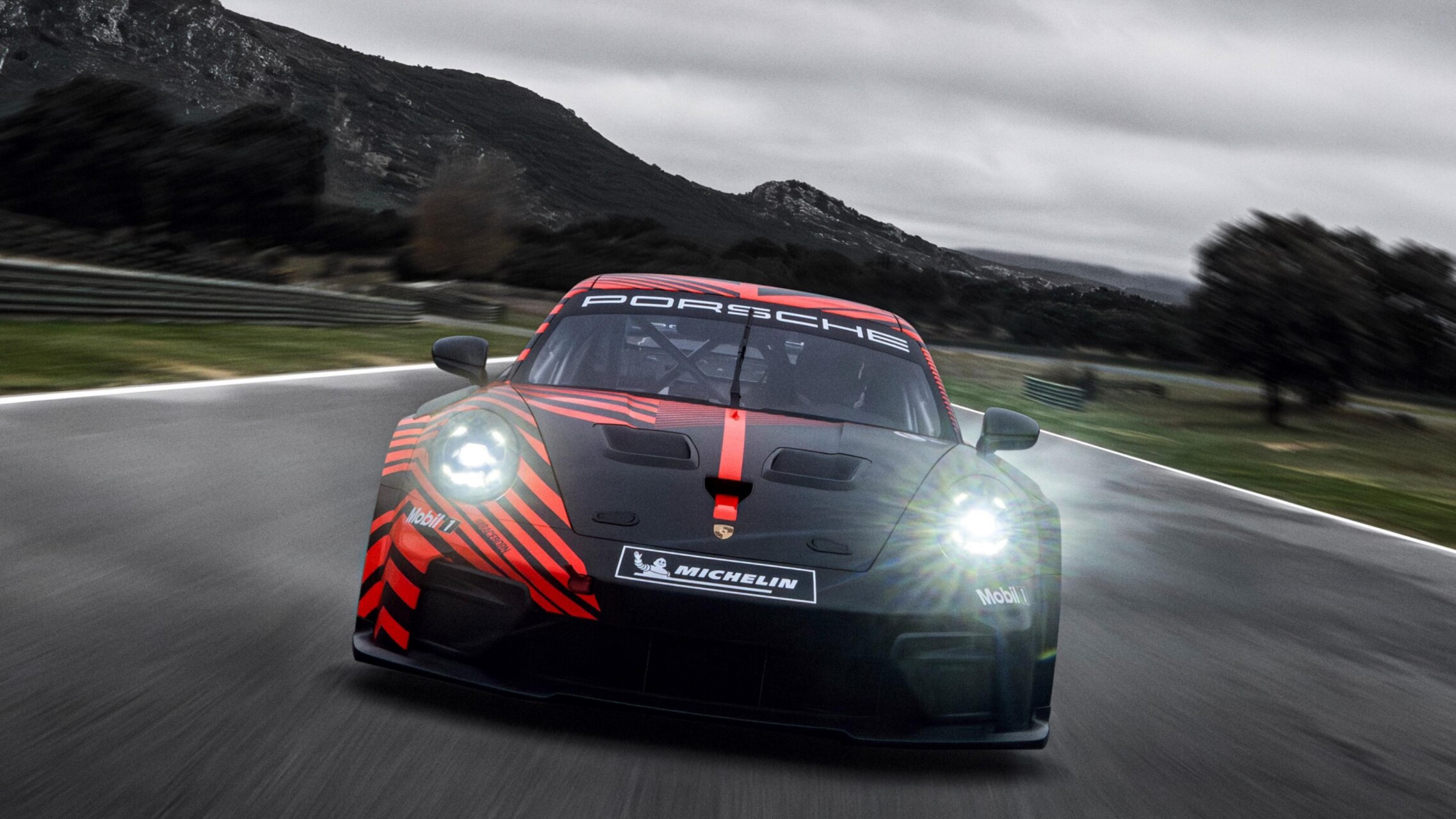 Porsche 911 GT4 R en pista con diseño aerodinámico y colores llamativos