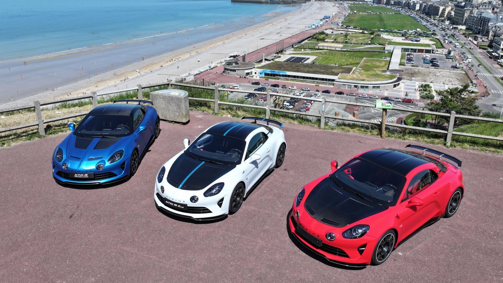 Tres modelos del Alpine A110 en un mirador junto a la playa de Dieppe