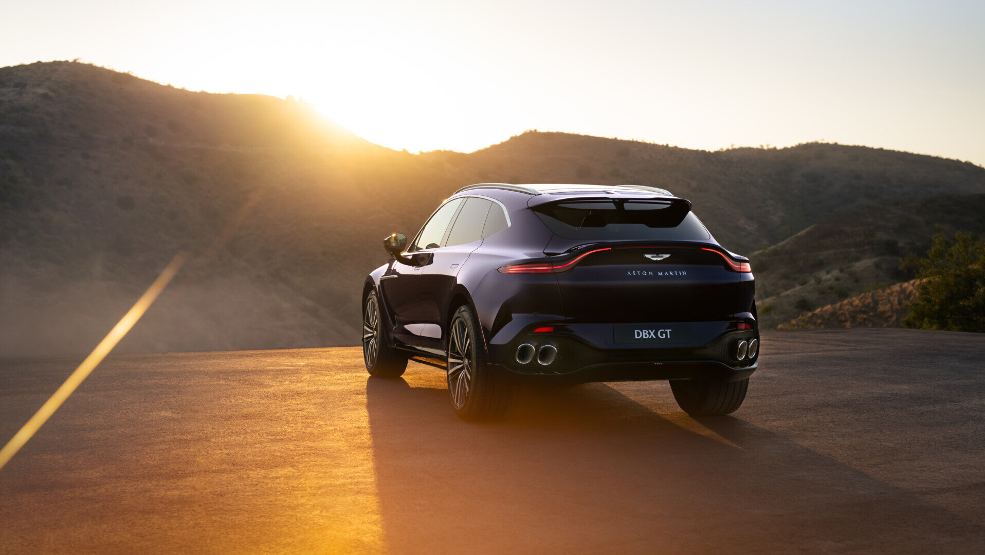 Aston Martin DBX GT en un paisaje montañoso al atardecer