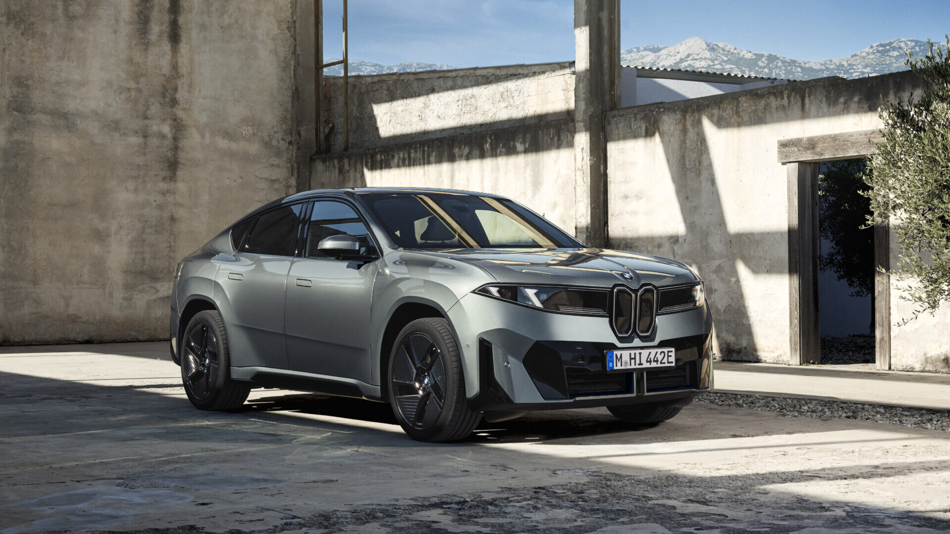 BMW iX4 2026 en un entorno arquitectónico moderno