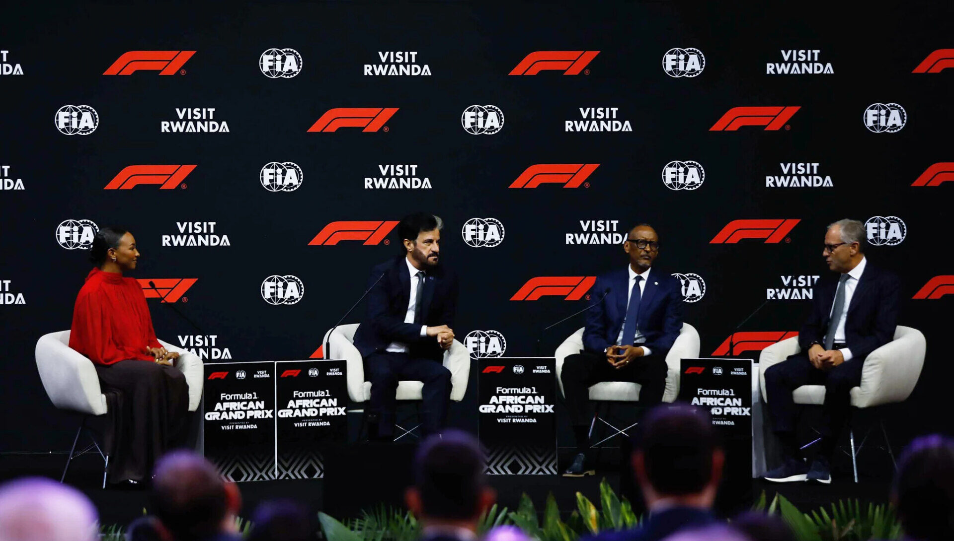 Cuatro personas sentadas en un escenario ante paneles del Gran Premio Africano de Fórmula 1.