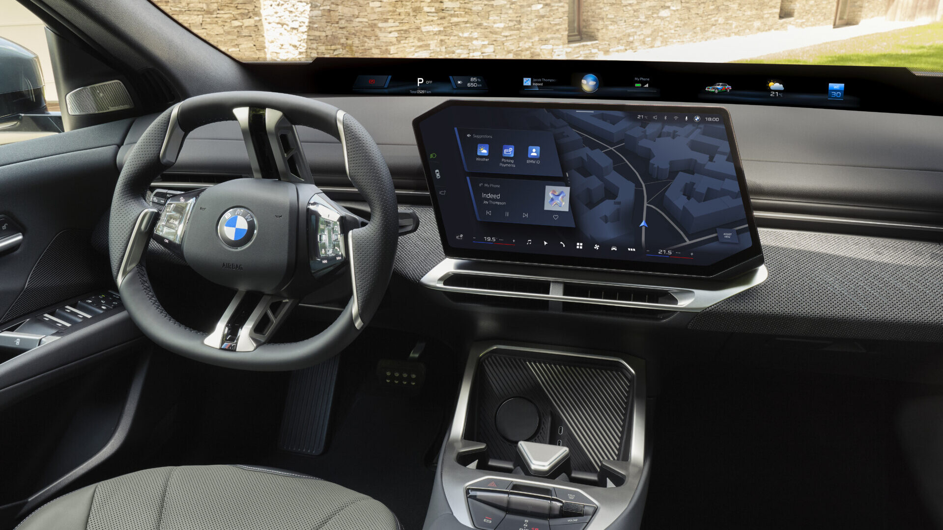 Interior del BMW iX4 2026 mostrando el volante y la pantalla central