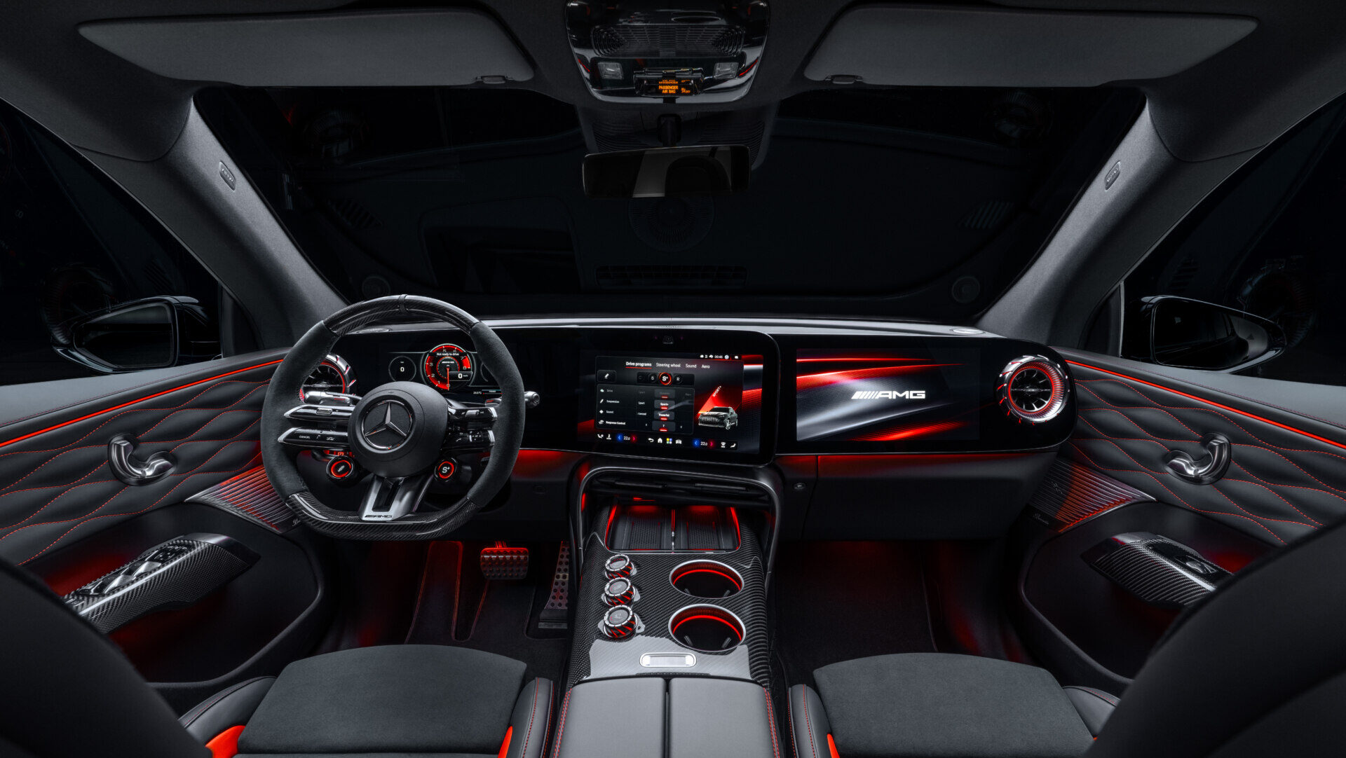 Interior de un Mercedes-AMG GT SUV con volante deportivo, pantallas y detalles iluminados en rojo