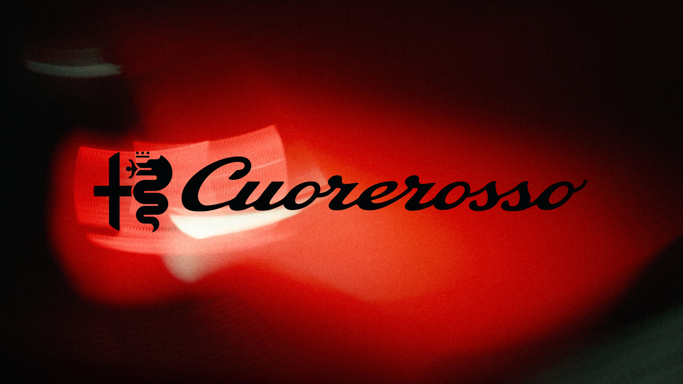 Logotipo negro de Cuorerosso sobre un fondo rojo iluminado y oscuro