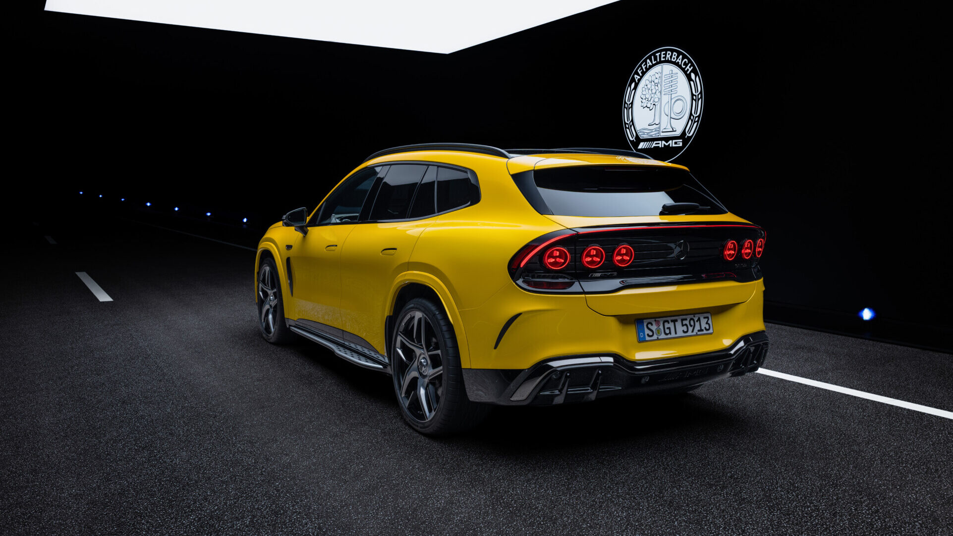 Representación de un SUV amarillo Mercedes-AMG visto desde atrás sobre una pista oscura.