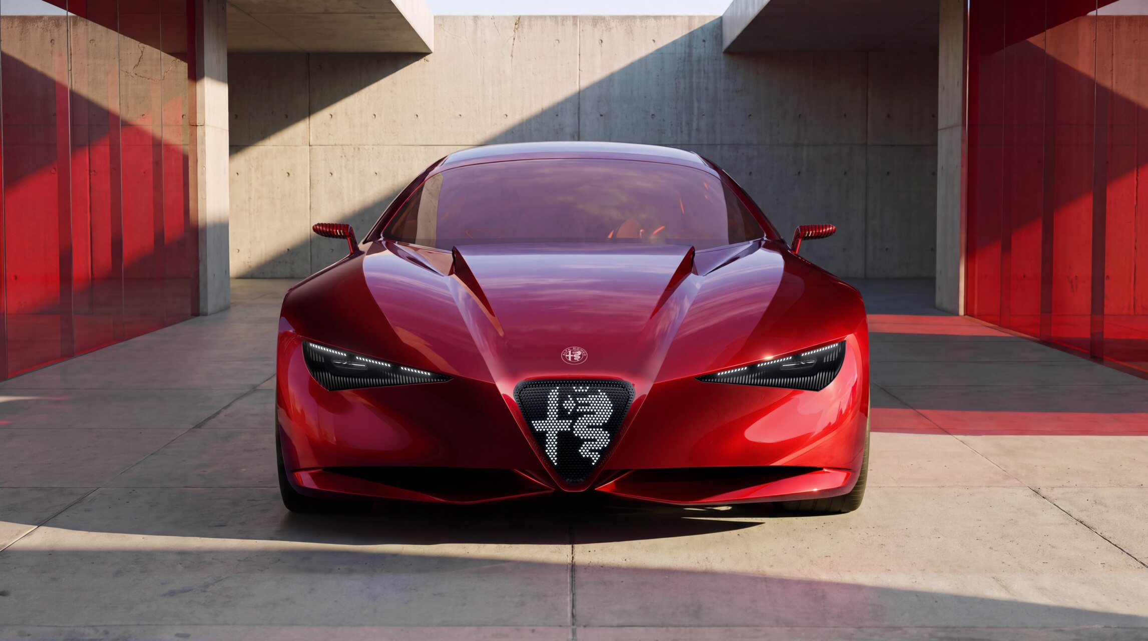 Prototipo Alfa Romeo rojo, visto de frente en un espacio de hormigón y vidrio.